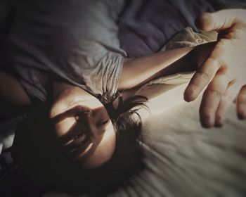 Midsection of woman lying down on bed