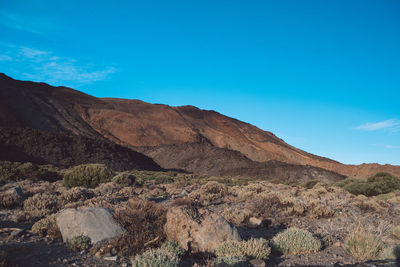 Scenic view of rocky mountains against blue sky