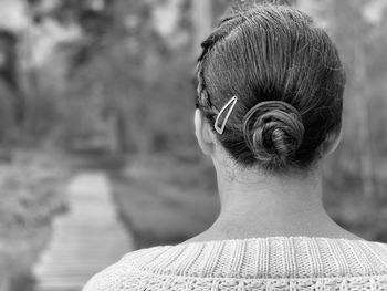 Black and white monochrome rear view of woman walking in woodlands