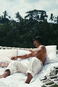 Young man lying on bed