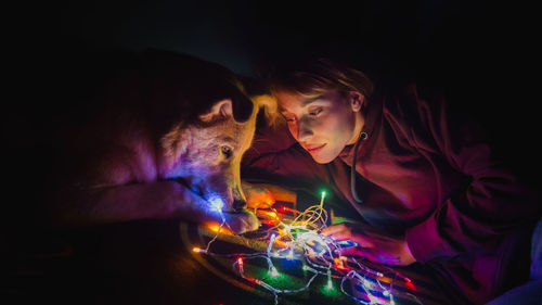 Woman looking at christmas lights with dog