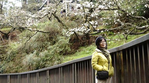 Portrait of woman standing on footbridge