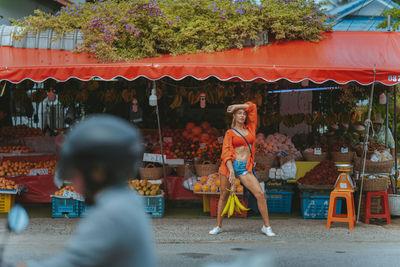 Rear view of woman sitting on street