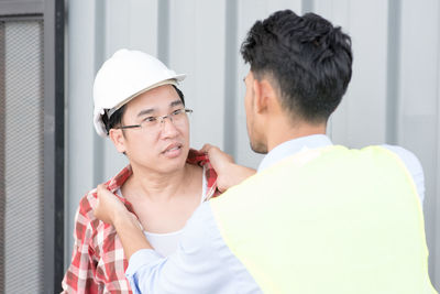 Coworkers arguing against corrugated iron