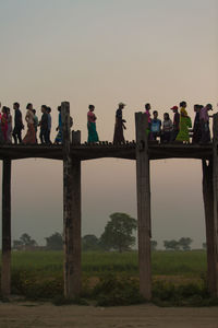 People working on bridge against clear sky