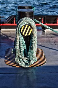 Close-up of rope tied to boat moored at harbor