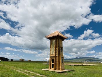 Traditional windmill on field against sky