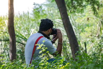 Man photographing in forest