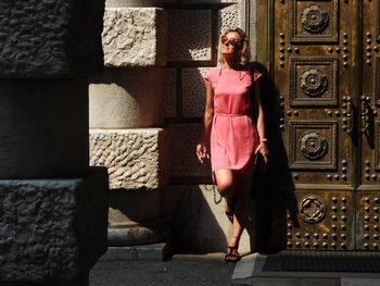 Portrait of woman against pink wall