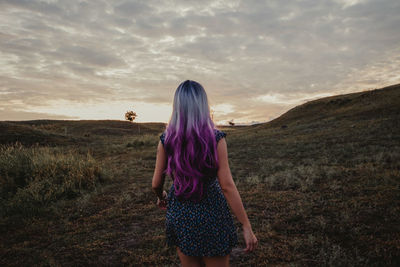 Rear view of woman standing on landscape