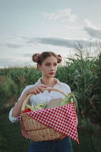 Portrait of young woman standing against sky