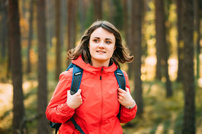 Portrait of young woman standing in forest