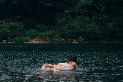 Woman with dog swimming in a water