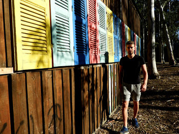 Full length portrait of young man standing against built structure