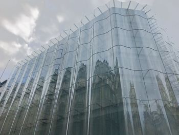 Low angle view of modern building against cloudy sky