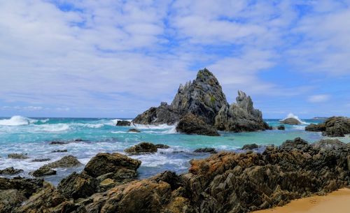 Rocks on beach against sky