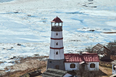 Lighthouse by sea against sky