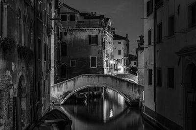 Bridge over canal in city against sky