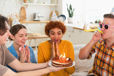 Portrait of smiling friends with food at home