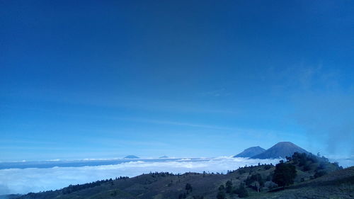 Scenic view of mountains against blue sky