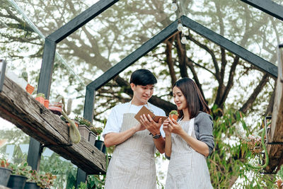 Smiling couple working in greenhouse