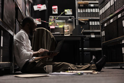 Rear view of man using laptop at airport