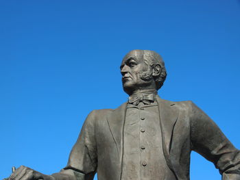Low angle view of statue against clear blue sky