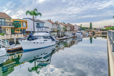 Boats moored at harbor against buildings in city