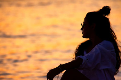 Side view portrait of woman looking at sunset