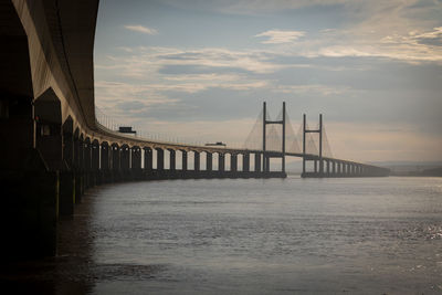 View of bridge over sea against cloudy sky