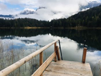 Wooden pier on lake against sky