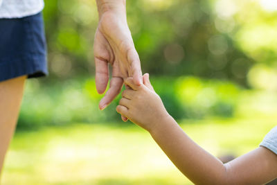 Close-up of hand holding hands against blurred background