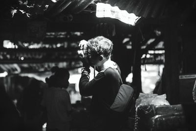 Rear view of people photographing at market