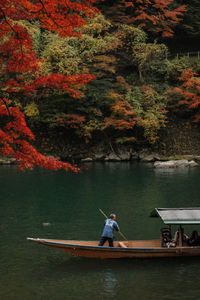 Man in boat on lake during autumn