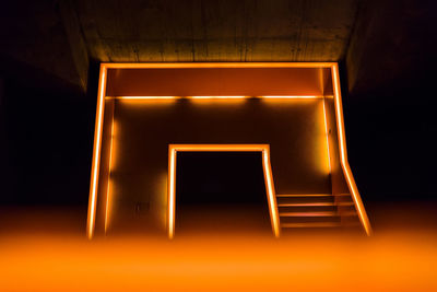 Empty illuminated lamp in dark room