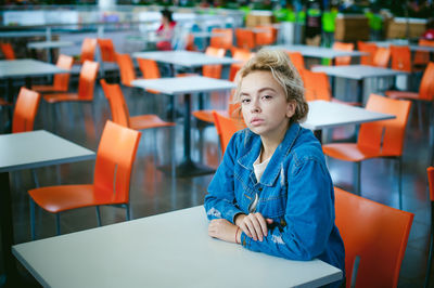 Portrait of woman sitting on chair at supermarket