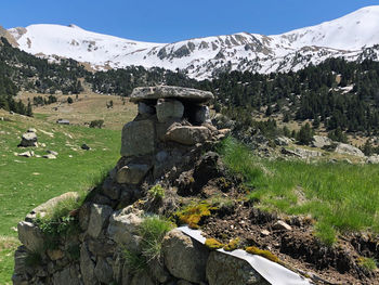 Scenic view of chimney tower with snowcapped mountains background against sky