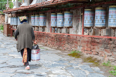 Rear view of man walking on footpath