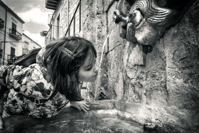 Girl drinking water from fountain