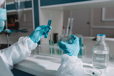 Midsection of scientist examining chemical in laboratory