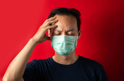 Portrait of mid adult woman against red background