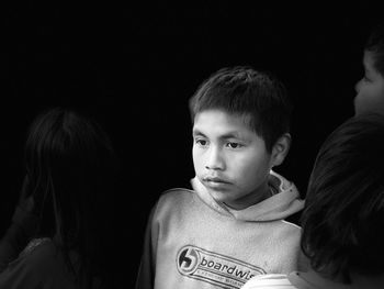 Portrait of boy against black background