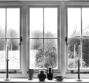 Containers and candlestick holders against window