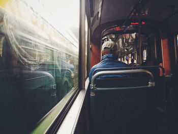 Rear view of man sitting in passenger train