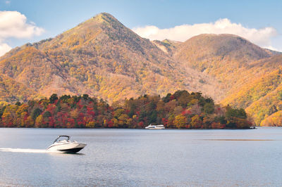 Scenic view of lake by mountain against sky