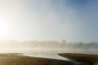 Scenic view of lake against sky at foggy weather