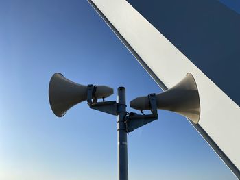 Low angle view of telephone pole against clear blue sky