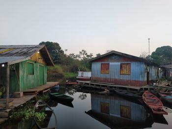 Houses by lake against sky