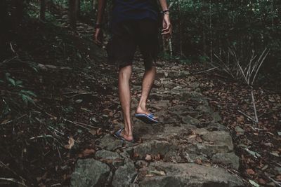 Low section of man walking in forest