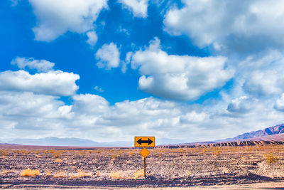 Road sign against sky